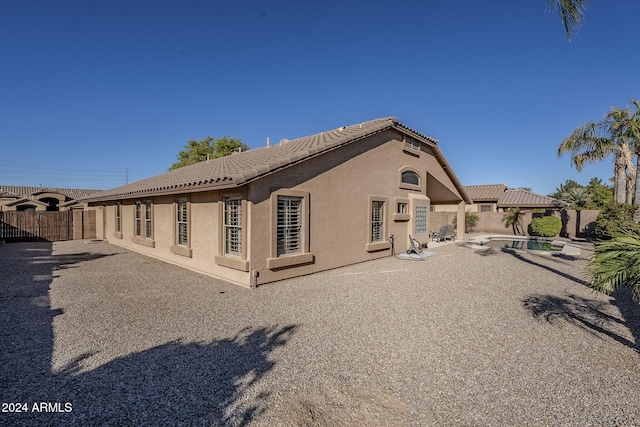 rear view of house with a fenced in pool, a patio area, and a gazebo