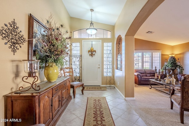 entrance foyer with lofted ceiling and light carpet