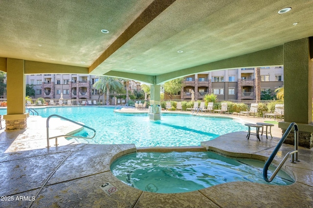 view of pool featuring a community hot tub and a patio area