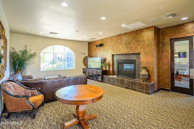 living room with a tile fireplace and carpet