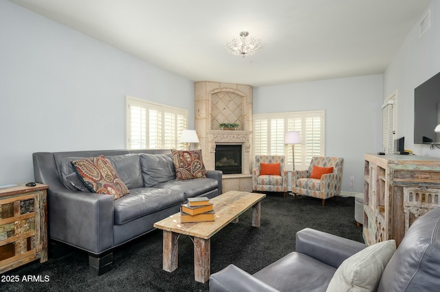 living room featuring a tiled fireplace and carpet floors