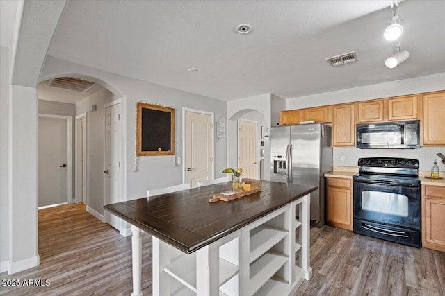 kitchen with hardwood / wood-style floors, a textured ceiling, and black appliances