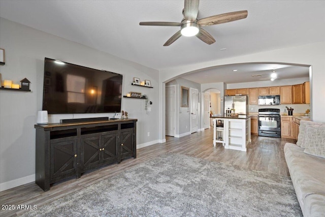 living room with ceiling fan and light wood-type flooring