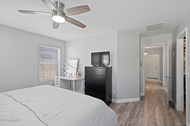 bedroom with light hardwood / wood-style floors and ceiling fan