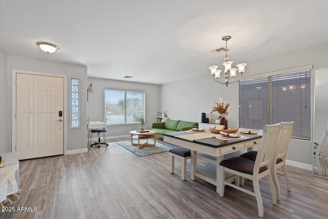 dining area with an inviting chandelier and hardwood / wood-style floors