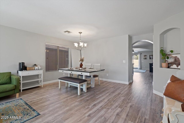 dining space featuring an inviting chandelier and light wood-type flooring