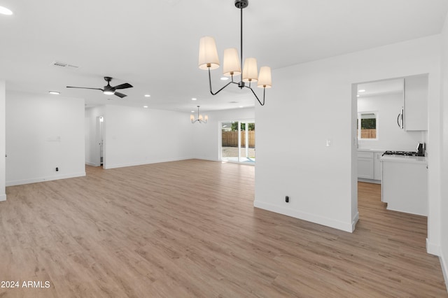 interior space with ceiling fan with notable chandelier and light hardwood / wood-style flooring