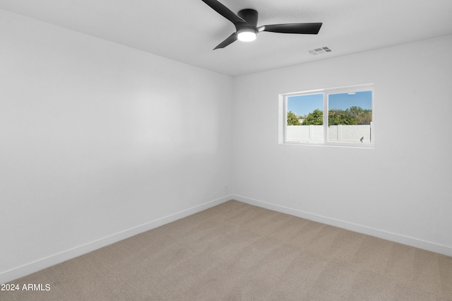 empty room featuring ceiling fan and light colored carpet