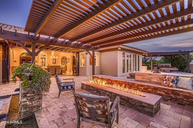 patio terrace at dusk featuring a pergola and an outdoor living space with a fire pit