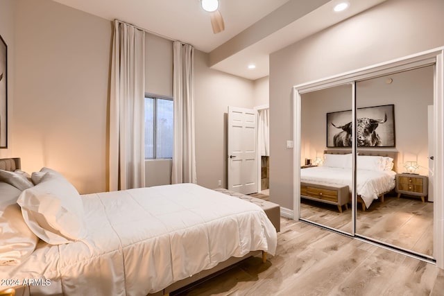 bedroom with ceiling fan, light wood-type flooring, and a closet