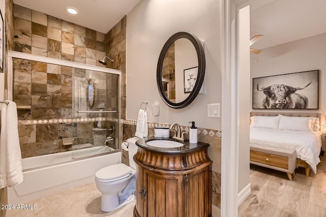 full bathroom with vanity, toilet, combined bath / shower with glass door, and wood-type flooring