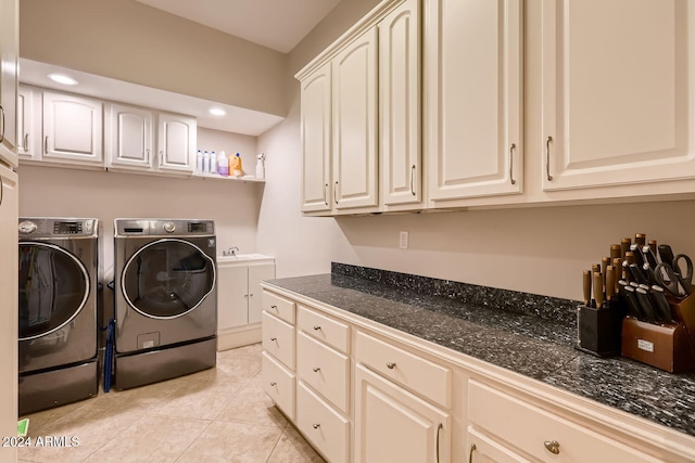 laundry room featuring cabinets, washing machine and dryer, light tile patterned floors, and sink