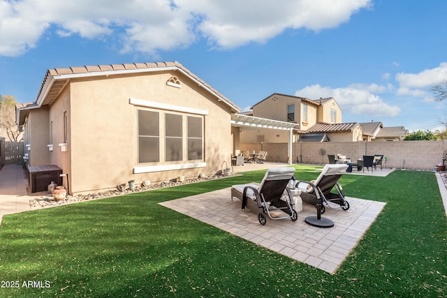 rear view of house featuring a yard and a patio area