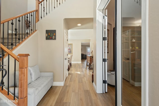 entrance foyer with a high ceiling and light wood-type flooring