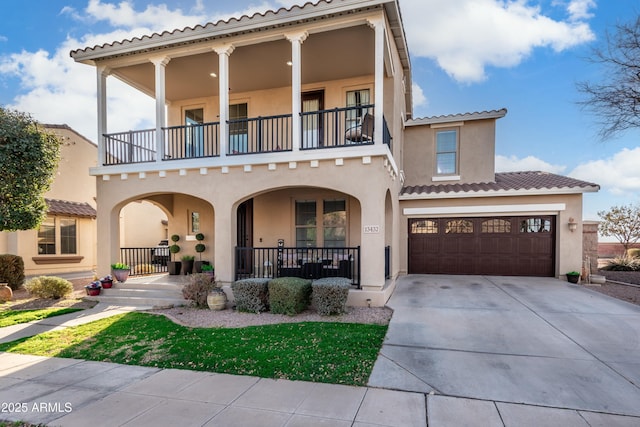 mediterranean / spanish house featuring a garage, a balcony, and a porch