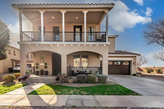 mediterranean / spanish-style house featuring a balcony, a garage, and covered porch