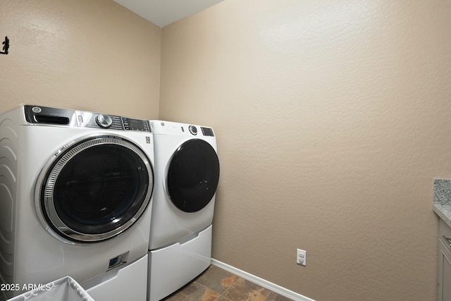 laundry room featuring cabinets and washer and clothes dryer