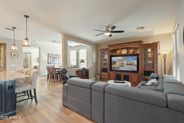 living room with ceiling fan and light wood-type flooring