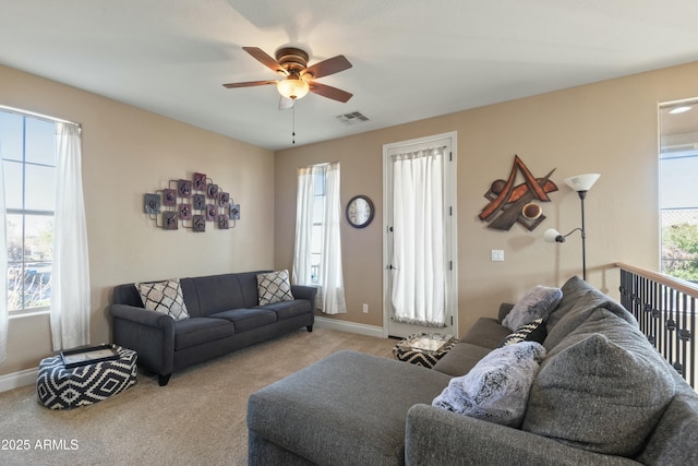 living room featuring plenty of natural light, light colored carpet, and ceiling fan