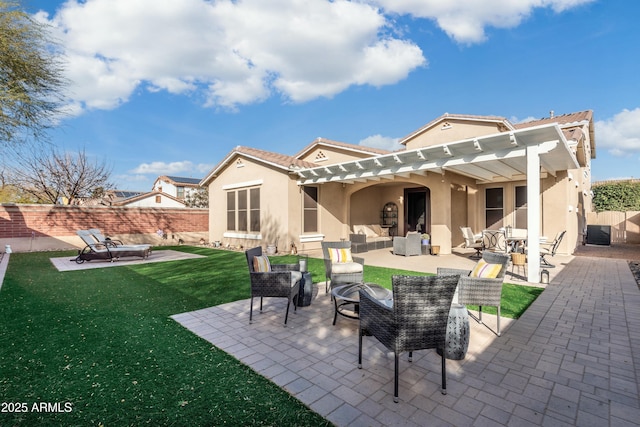 back of house featuring a yard, a patio, and an outdoor living space with a fire pit