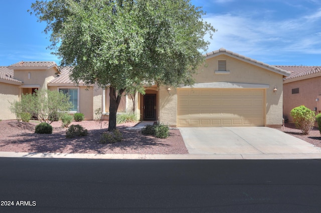 view of front of property with driveway, an attached garage, and stucco siding