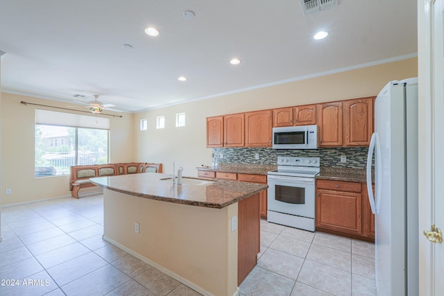 kitchen with white appliances, visible vents, a sink, crown molding, and tasteful backsplash