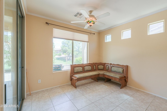 living area featuring light tile patterned floors, visible vents, baseboards, ceiling fan, and ornamental molding