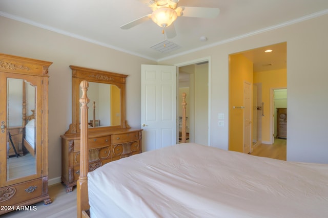 bedroom featuring crown molding, visible vents, light wood-style floors, ceiling fan, and baseboards