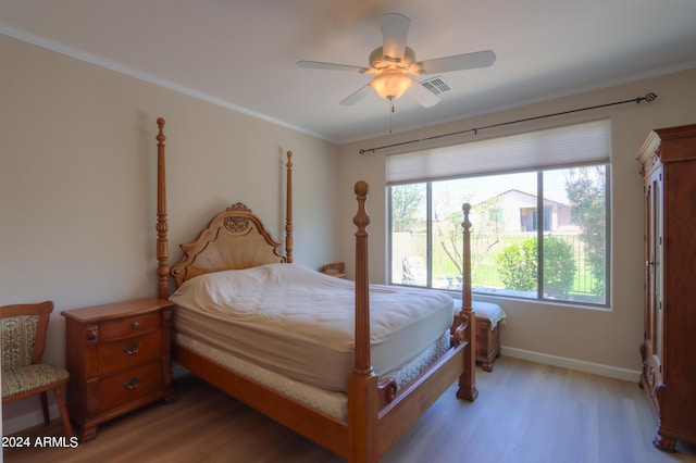 bedroom featuring visible vents, ornamental molding, a ceiling fan, light wood finished floors, and baseboards