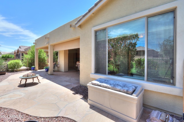 view of patio featuring an outdoor fire pit and fence