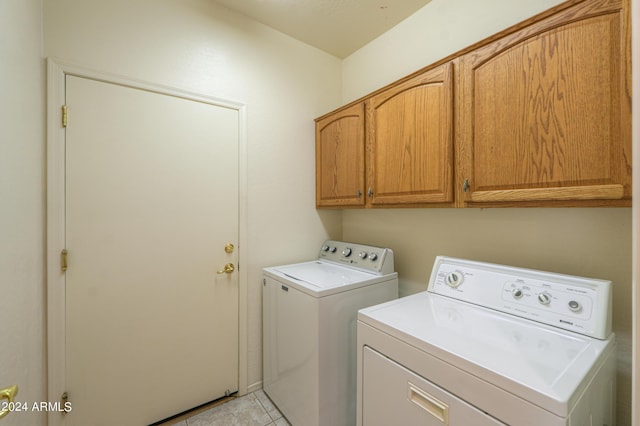 clothes washing area featuring cabinet space, washing machine and dryer, and light tile patterned floors