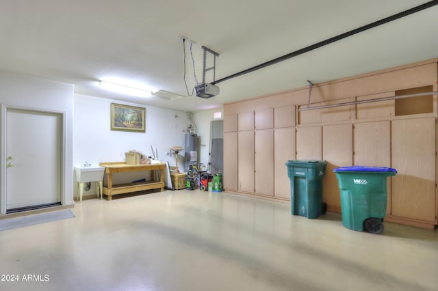 garage featuring a garage door opener, gas water heater, and a sink