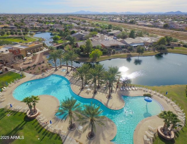 community pool with a water view, a residential view, and a patio