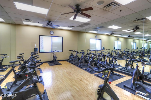 exercise room featuring visible vents, a drop ceiling, and wood finished floors