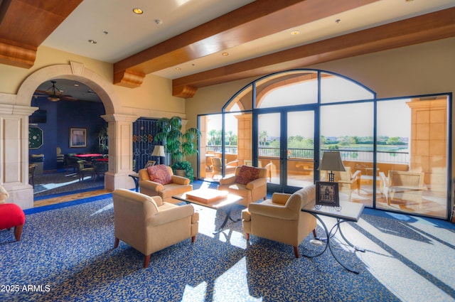 living room with beamed ceiling, recessed lighting, french doors, arched walkways, and decorative columns