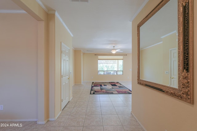 hallway featuring light tile patterned flooring, visible vents, baseboards, and ornamental molding