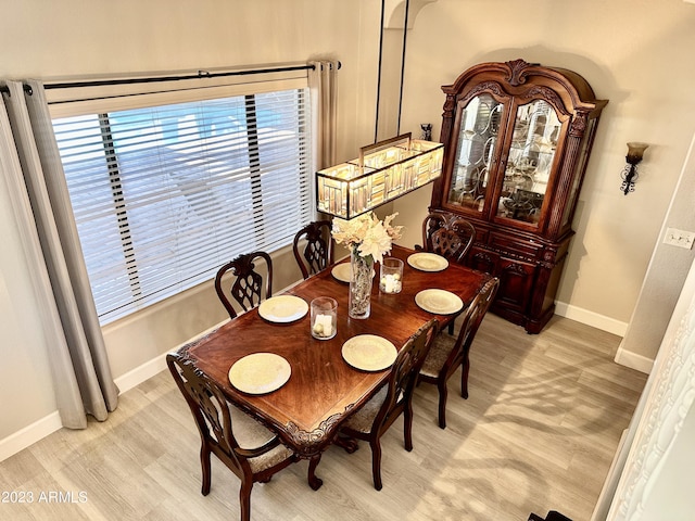 dining room with light wood-type flooring and baseboards