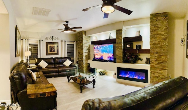 living room with visible vents, ceiling fan, and a glass covered fireplace