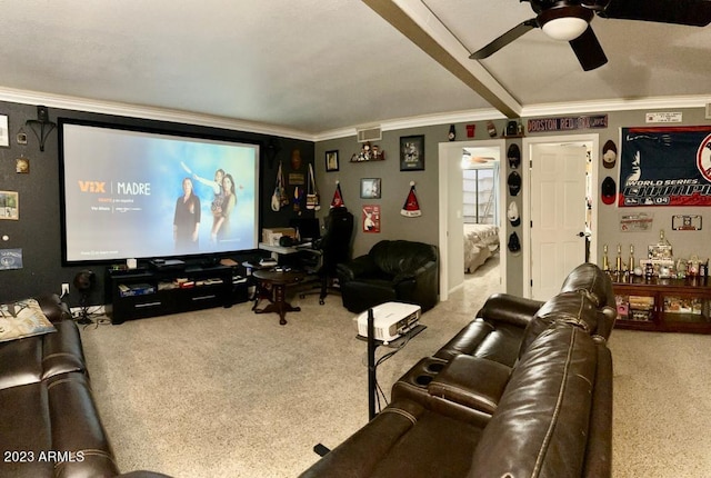 carpeted home theater room with visible vents, crown molding, and ceiling fan