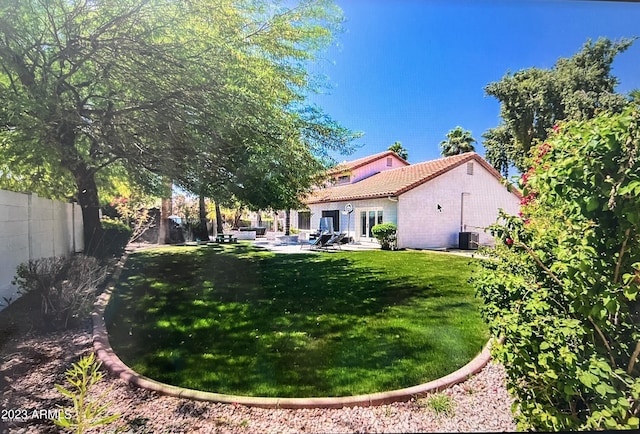 view of yard with central AC unit, a patio, and a fenced backyard