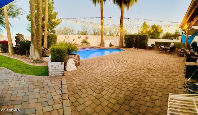 view of pool featuring a patio area, a fenced in pool, outdoor dining area, and a fenced backyard