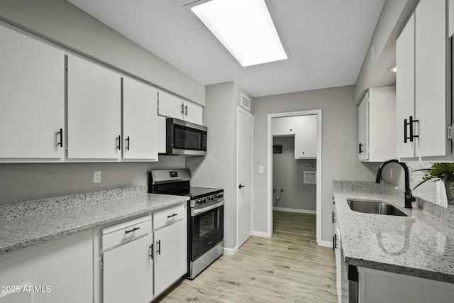 5148 E Edgewood Cir, Mesa, AZ 85206 - kitchen featuring appliances with stainless steel finishes, white cabinets, light wood-type flooring, and light stone countertops