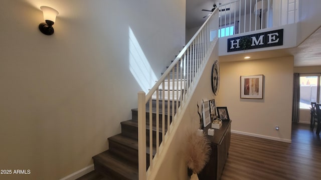 stairs with hardwood / wood-style flooring and a towering ceiling