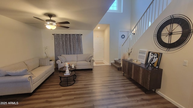 living room featuring ceiling fan, dark hardwood / wood-style floors, and a high ceiling