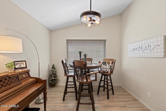 dining area with vaulted ceiling and light hardwood / wood-style flooring