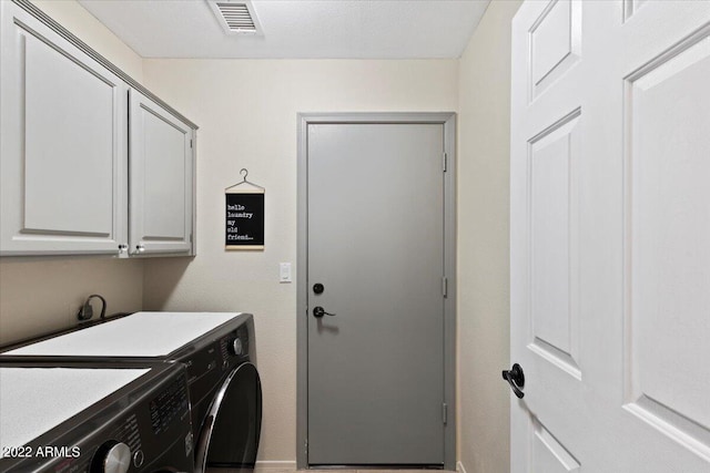 washroom featuring cabinets and washing machine and dryer