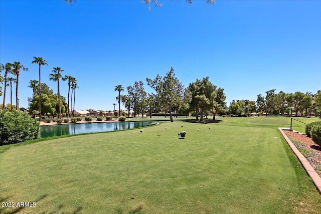 surrounding community featuring a water view and a lawn