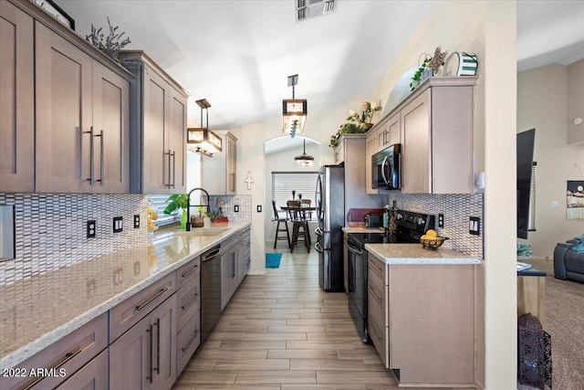 kitchen featuring decorative backsplash, sink, light hardwood / wood-style floors, hanging light fixtures, and appliances with stainless steel finishes