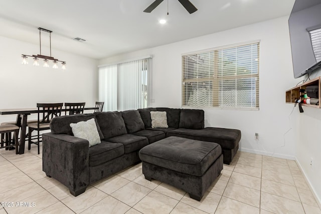 living room with baseboards, ceiling fan, light tile patterned flooring, and plenty of natural light