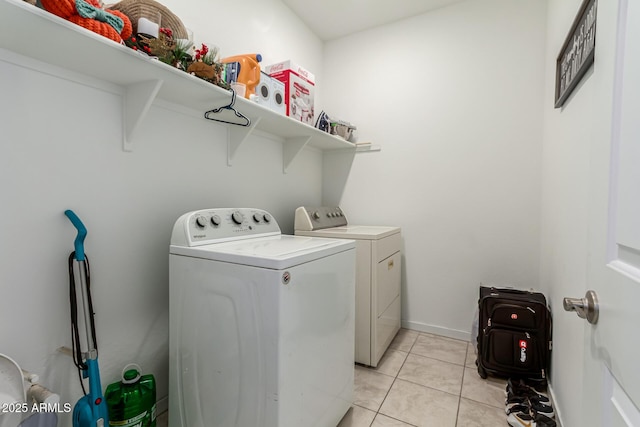 laundry room with baseboards, light tile patterned flooring, laundry area, and independent washer and dryer